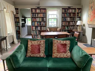 a green couch with pillows in a living room at Barns Library in Peebles
