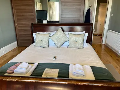 a large bed with towels and pillows on it at Ardmor Guest House in Oban