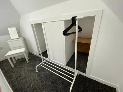 a mirror in a room with a chair and a desk at The Wee Cottage by the Ferry in Gourock