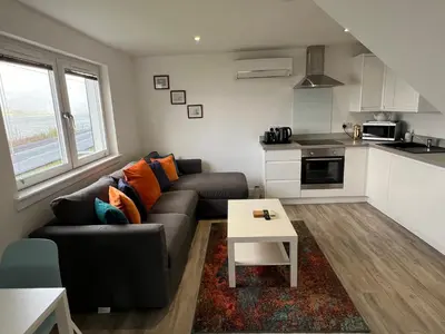a living room with a couch and a table at The Wee Cottage by the Ferry in Gourock