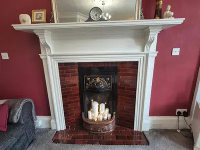 a fireplace with a white mantle with candles in it at Brae View Coastal Gem in Largs