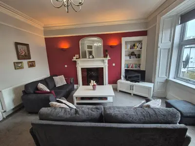 a living room with two couches and a fireplace at Brae View Coastal Gem in Largs