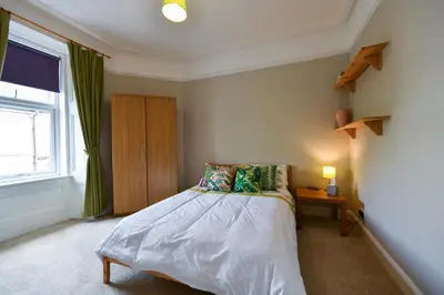 a small bedroom with a bed and a window at Brae View Coastal Gem in Largs