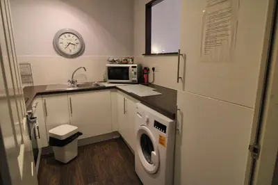 a kitchen with a washing machine and a microwave at Ayr Apartment with Sea and Countryside views in Ayr