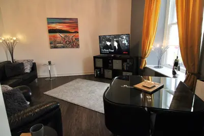 a living room with a table and a television at Ayr Apartment with Sea and Countryside views in Ayr