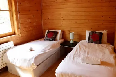 a room with two beds in a log cabin at Lodge 38 Rowardennan , Loch Lomond in Glasgow