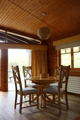 a dining room with a wooden table and chairs at Lodge 37 Rowardennan, Loch Lomond in Glasgow