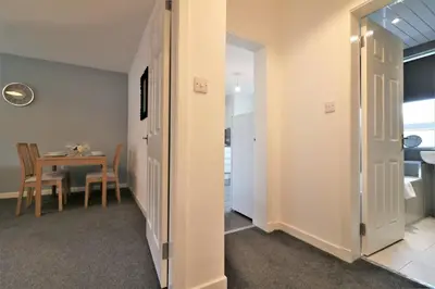 a hallway with a table and a dining room at Signature - Newbattle House in Chapelhall