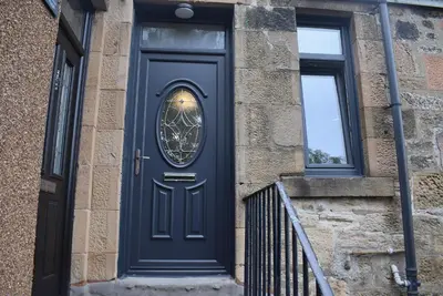 a blue door with a window on a brick building at Kelpies Serviced Apartments- Victoria in Falkirk