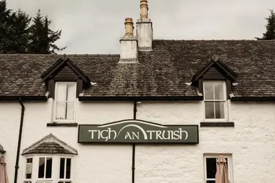 a sign on the side of a white building at Tigh an Truish Inn in Oban