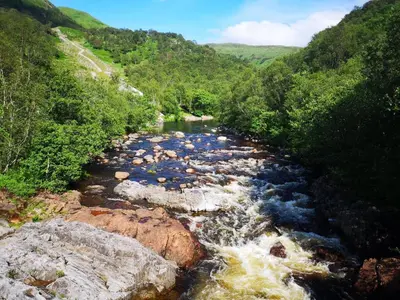 a river with rapids and rocks in a valley at Forest View Guesthouse, Kinlochleven WHW in Kinlochmore