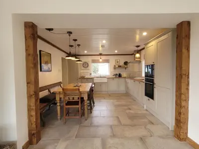 a kitchen with a wooden table and a dining room at Blair Cottage in Rowardennan