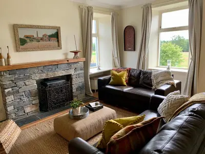 a living room with a couch and a fireplace at Blair Cottage in Rowardennan