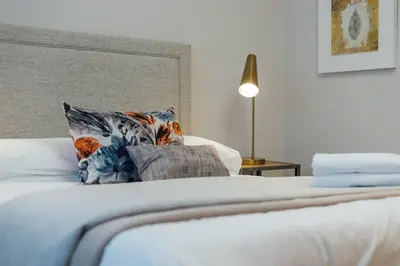 a bedroom with a bed with a pillow and a lamp at Glasgow Central Luxury Apartment in Glasgow