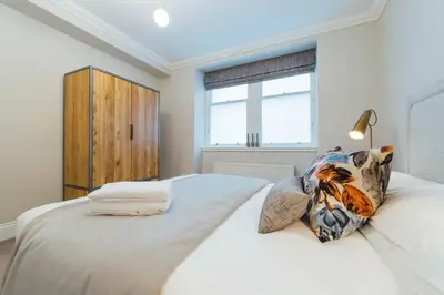 a bedroom with a large white bed with a window at Glasgow Central Luxury Apartment in Glasgow