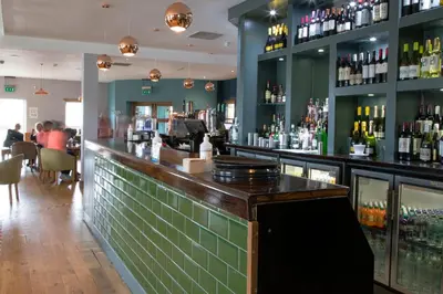 a bar in a restaurant with bottles of alcohol at The Boat House in Kilsyth