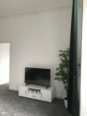 a flat screen tv sitting on top of a white entertainment center at Carvetii - Edward House A - 2 Dbl bed 1st floor flat in Dunfermline