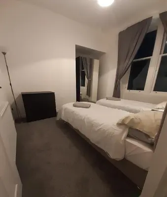 a bedroom with two beds and two windows at Carvetii - Edward House A - 2 Dbl bed 1st floor flat in Dunfermline