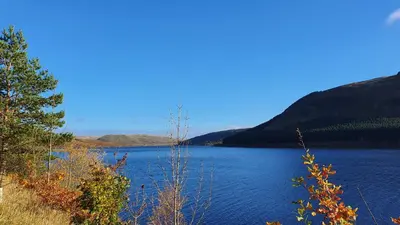 a large blue lake with mountains in the background at Kirkview House in Moffat