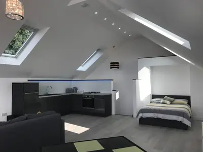 a living room with a bed and a kitchen at 1 Bed Studio - Sleeps 4 - Parking - Wifi in Saint Davids