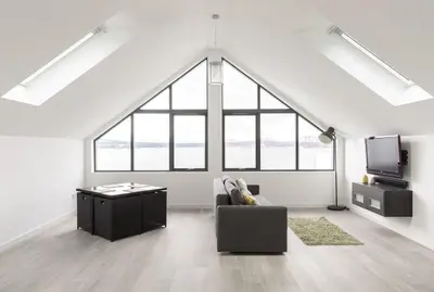 a living room with a couch and a tv in a loft at 1 Bed Studio - Sleeps 4 - Parking - Wifi in Saint Davids