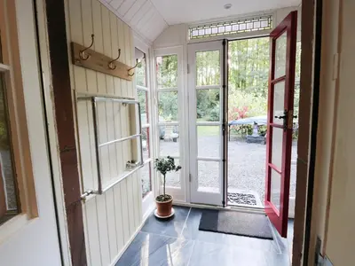 a hallway with a door and a potted plant at The Coach House in Newton Stewart