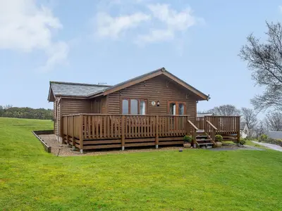 a small wooden cabin with a large deck at Ard Cuan in Torbeg