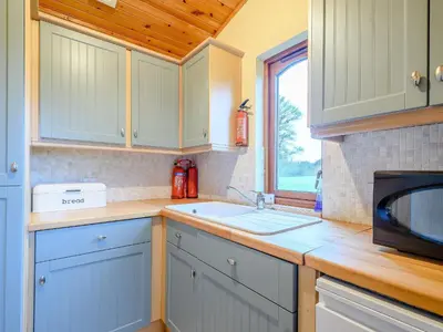a kitchen with a sink and a microwave at Ard Cuan in Torbeg
