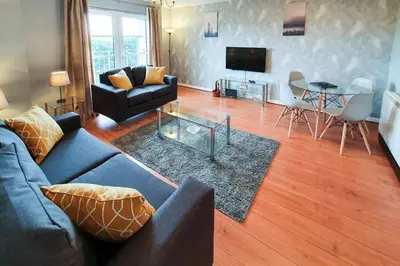 a living room with a couch and a table at Hilton Wynd Apartment in Rosyth
