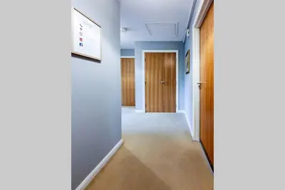 a hallway with blue walls and a door at Hilton Wynd Apartment in Rosyth