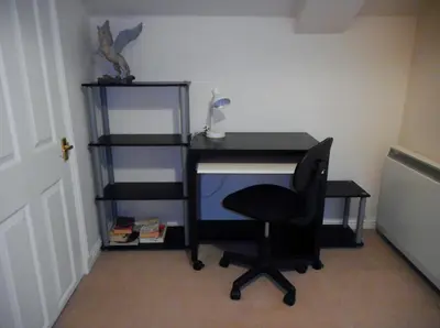 a desk with a chair and a computer monitor at DairyCottage, 5, TELFORD MEWS BEATTOCK in Moffat