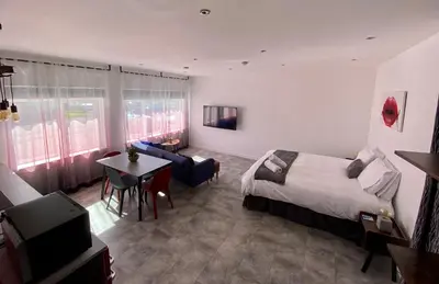 a hotel room with a bed and a table and a television at Dalgety Bay Luxury Studio Apartment in Saint Davids