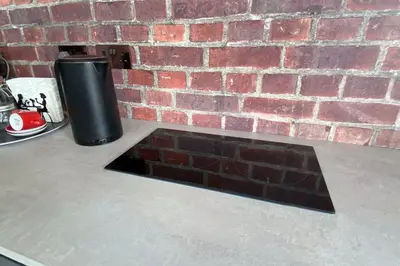 a trash can sitting on a counter next to a brick wall at Dalgety Bay Luxury Studio Apartment in Saint Davids