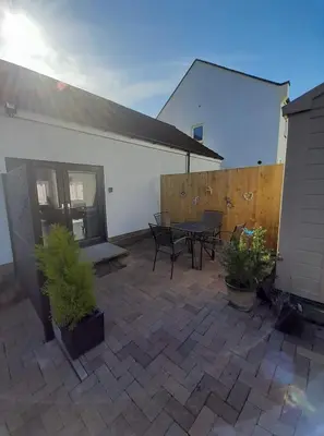 a patio with a table and chairs and a building at Dalgety Bay Luxury Studio Apartment in Saint Davids