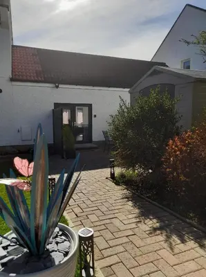 a patio with a potted plant and a building at Dalgety Bay Luxury Studio Apartment in Saint Davids