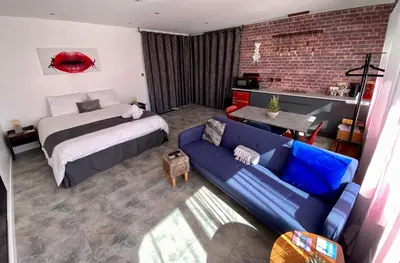 a bedroom with a bed and a blue couch at Dalgety Bay Luxury Studio Apartment in Saint Davids