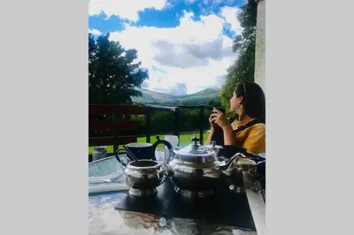a woman sitting at a table looking at her cell phone at North Lodge Kilmun in Kilmun