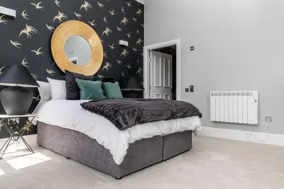 a bedroom with a large bed and a mirror at Beautiful 4 bed flat in perfect central location in Glasgow