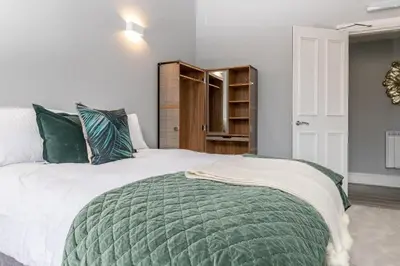 a bedroom with a large bed with a green blanket at Beautiful 4 bed flat in perfect central location in Glasgow