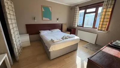 a bedroom with a bed with two towels on it at Lomond Park Hotel in Balloch