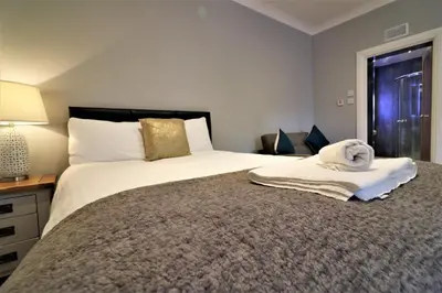 a bedroom with a bed with a towel on it at Signature - Linden Cottage Room 1 in Airdrie