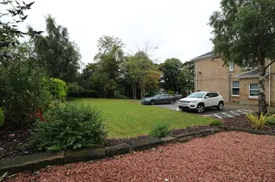a yard with two cars parked in a parking lot at Signature - Linden Cottage Room 1 in Airdrie