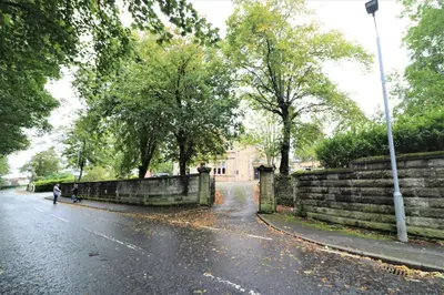 a person walking down a street in the rain at Signature - Linden Cottage Room 2 in Airdrie