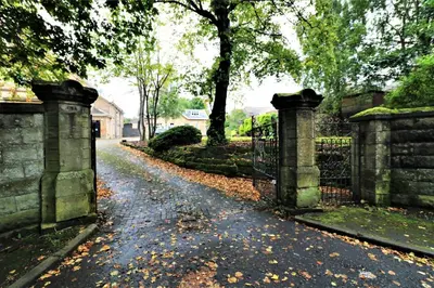 a gate in a yard with leaves on the ground at Signature - Linden Cottage Room 4 in Airdrie