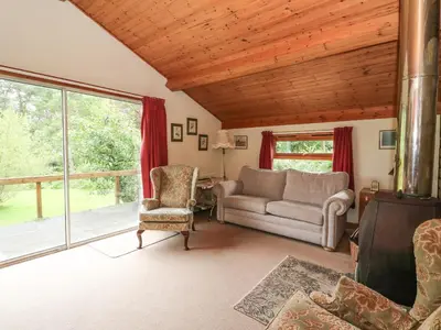 a living room with a couch and a chair at Millmore Cabin in Killin