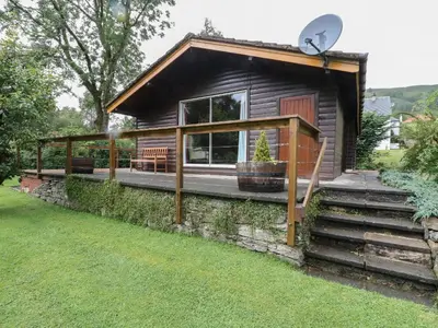 a tiny house with a porch and a satellite at Millmore Cabin in Killin