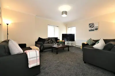 a living room with two couches and a tv at Signature - Kirkhill House in Kirkmuirhill