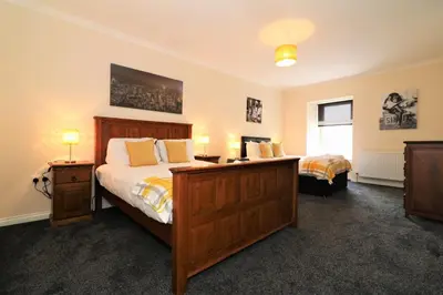 a bedroom with two beds and two lamps and a window at Signature - Kirkhill House in Kirkmuirhill