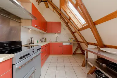 a kitchen with red cabinets and a stove top oven at Rabbie Burns Lodge in Maybole