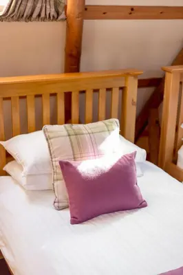 a bed with four pillows on top of it at Rabbie Burns Lodge in Maybole